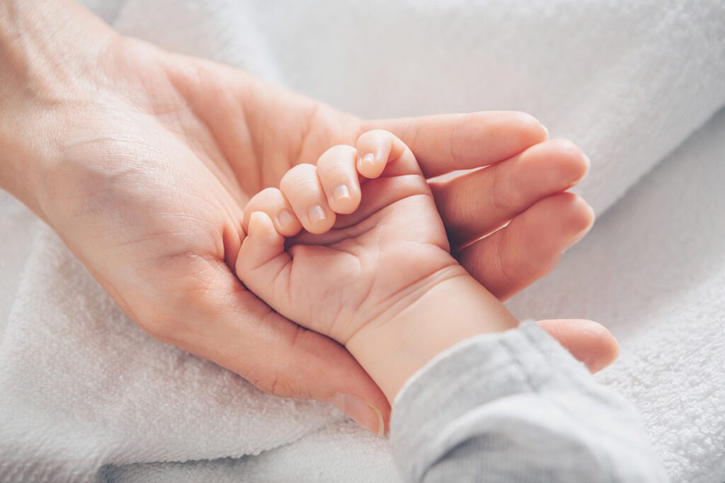 Parent Holding Newborn Babys Hand After Cord Blood Banking with Miracle Cord
