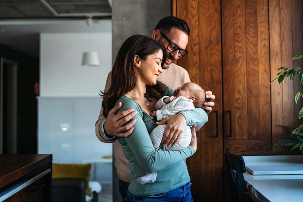 Happy Parents Holding Newborn Baby at Home After Cord Tissue Banking
