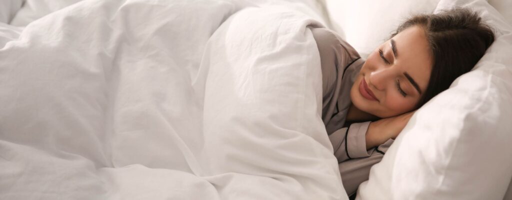 women sleep in a bed happily